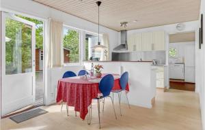 a kitchen with a table and blue chairs at 2 Bedroom Cozy Home In Nexø in Neksø