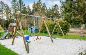 a playground with a swing set in the sand at 2 Bedroom Cozy Home In Nexø in Neksø +16 photos