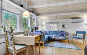 a living room with a blue couch and a table at 2 Bedroom Cozy Home In Jægerspris in Jægerspris