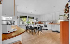 a white kitchen with a table and chairs at 3 Bedroom Amazing Home In Frederikshavn in Frederikshavn
