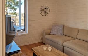 een woonkamer met een bank en een tafel bij Awesome Home In Risr With House Sea View in Risør