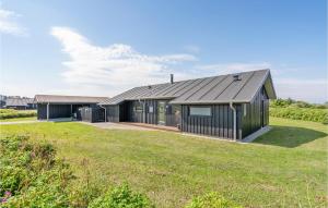 uma casa com um telhado preto e um quintal em Amazing Home In Hjrring With Sauna em Hjørring