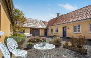 a courtyard of a house with chairs and a table at 2 Bedroom Beautiful Apartment In Rnne in Rønne