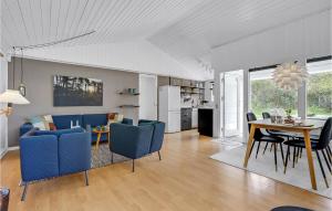a dining room and living room with blue chairs and a table at 3 Bedroom Pet Friendly Home In Ålbæk in Ålbæk