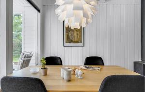 a dining room table with chairs and a chandelier at 3 Bedroom Pet Friendly Home In Ålbæk in Ålbæk