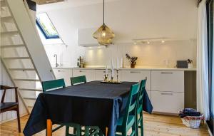 a kitchen with a table with a black table cloth and green chairs at Awesome Home In Aakirkeby With Wifi in Vester Sømarken