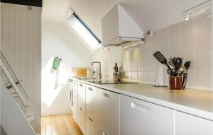 a kitchen with white cabinets and a skylight at Awesome Home In Aakirkeby With Wifi in Vester Sømarken