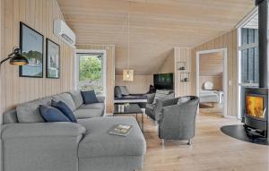 een woonkamer met een bank en stoelen en een open haard bij Cozy Home In Lgstrup With Kitchen in Løgstrup