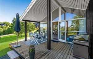 een huis met een terras met een tafel en stoelen bij Cozy Home In Lgstrup With Kitchen in Løgstrup
