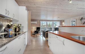 cocina con armarios blancos y techo de madera en Awesome Home In Vestervig With Wifi, en Vestervig