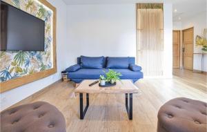 a living room with a blue couch and a table at Beautiful Home In Angerville-lorcher With Wifi in Angerville-lʼOrcher