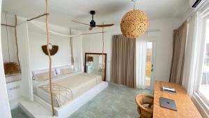 a bedroom with a bed and a table in it at Guru Canggu in Canggu