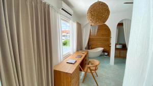 a bathroom with a desk and a tub and a window at Guru Canggu in Canggu