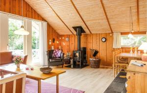 ein Wohnzimmer mit Holzvertäfelung und Holzofen in der Unterkunft 3 Bedroom Cozy Home In Nexø in Neksø