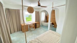 a bathroom with a tub and a desk and a mirror at Guru Canggu in Canggu