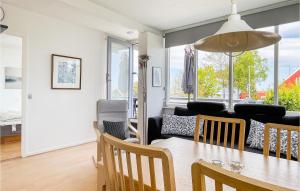 a dining room and living room with a table and chairs at Awesome Apartment In Allinge With Wifi in Allinge