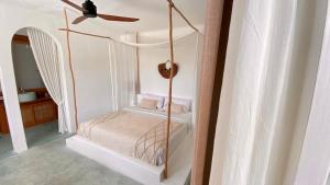a bedroom with a canopy bed with a ceiling fan at Guru Canggu in Canggu