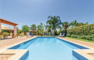 a swimming pool in a yard with palm trees at Villa Gina in Menfi