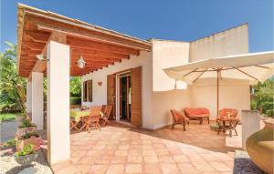 a patio with a table and chairs and an umbrella at Villa Gina in Menfi