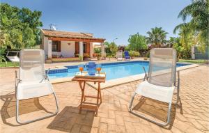 two chairs and a table in front of a pool at Villa Gina in Menfi