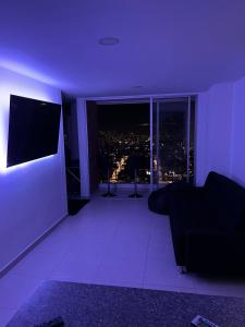 Apartamento privado con vista en el centro de B/ga في بوكارامانغا: غرفة أرجوانية مع أريكة وإطلالة على المدينة