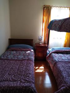 a bedroom with two beds next to a window at Casa en algarrobo in Algarrobo