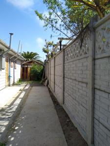 un mur de briques avec un trottoir à côté d'une clôture dans l'établissement Casa en algarrobo, à Algarrobo