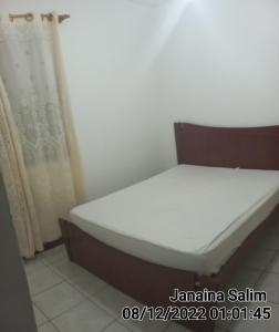 een klein bed in een kamer met ventilator bij Casa lagoa shopping Cabo Frio in Cabo Frio
