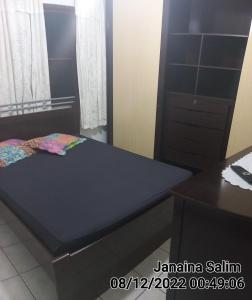een bed in een kamer met een bureau en een bed sidx sidx sidx bij Casa lagoa shopping Cabo Frio in Cabo Frio