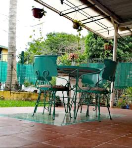 una mesa y sillas al aire libre bajo una pérgola en Mi Otoch en Cancun jardín terraza asador, en Cancún