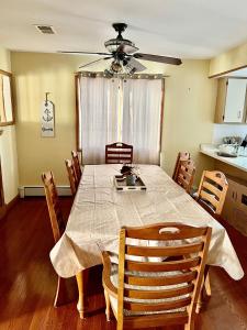 a dining room table with chairs and a ceiling fan at Shore house on Pelican Island! in Seaside Heights