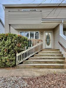 une maison avec des escaliers menant à la porte d'entrée. dans l'établissement Shore house on Pelican Island!, à Seaside Heights