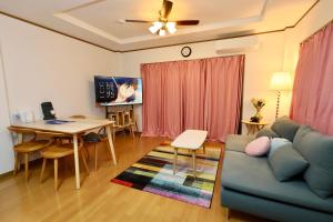 a living room with a couch and a table at Guest House Kubo Homes Matsu in Osaka