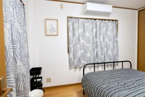 a bedroom with a bed and a window at Guest House Kubo Homes Matsu in Osaka