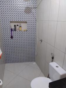 a white bathroom with a toilet and a shower at Casa em São Thomé das Letras in São Thomé das Letras +4 photos