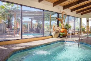 a swimming pool in a house with a large window at Azure Palm Hot Springs in Desert Hot Springs