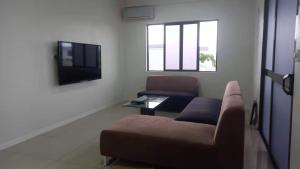 a living room with a couch and a tv at Gardenia Apartment-03 in Nadi