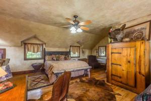 a bedroom with a bed and a ceiling fan at Last Outpost Bandera Ranch House in Bandera