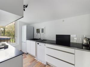 eine Küche mit weißen Schränken und schwarzen Arbeitsplatten in der Unterkunft Maison Saint-Rémy-de-Provence, 6 pièces, 8 personnes - FR-1-599-74 in Saint-Rémy-de-Provence
