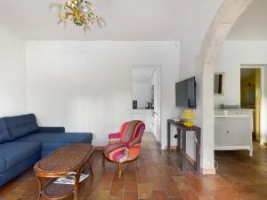 ein Wohnzimmer mit einem blauen Sofa und einem Tisch in der Unterkunft Maison Saint-Rémy-de-Provence, 6 pièces, 8 personnes - FR-1-599-74 in Saint-Rémy-de-Provence