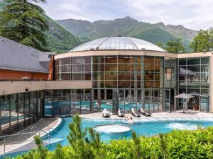 an exterior view of a building with a swimming pool at Appartement Cauterets, 2 pièces, 4 personnes - FR-1-401-252 in Cauterets