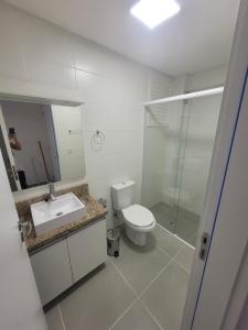 uma casa de banho com um WC, um lavatório e um chuveiro em Lindo apartamento 1 quarto em Capão da Canoa