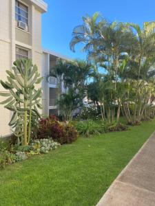 a garden in front of a building with palm trees at Pearlridge Gardens and Tower Aiea, Hawaii 96701 in Aiea