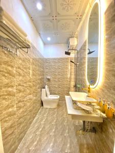 a bathroom with a sink and a toilet and a mirror at Lan Rừng Homestay in Lũng Niêo