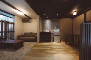 Large family accommodation Tsuji family - Vacation STAY 20952v في Mitoyo: غرفة معيشة مع أريكة ومطبخ