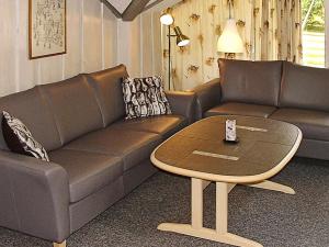 ein Wohnzimmer mit einem Sofa und einem Tisch in der Unterkunft 6 person holiday home in Hemmet in Falen