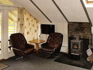 2 Stühle und ein Tisch im Wohnzimmer mit Kamin in der Unterkunft 6 person holiday home in Hemmet in Falen