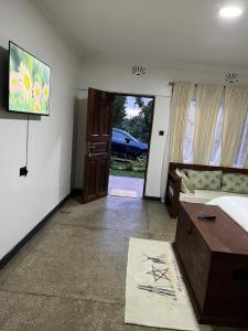 a bedroom with a bed and a table and a door at Koselig Homes in Nanyuki