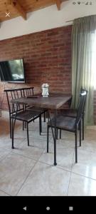Departamento en Trelew في تريليو: طاولة خشبية مع كرسيين وطاولة وكراسي