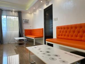 an orange couch and a table in a room at Rangya Hotel in Tagaytay